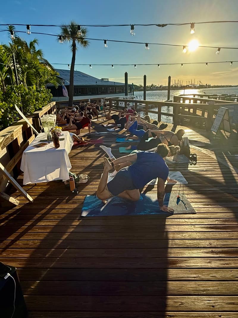 Students flowing on the Bonita Fish Company deck as the sun rises over the water